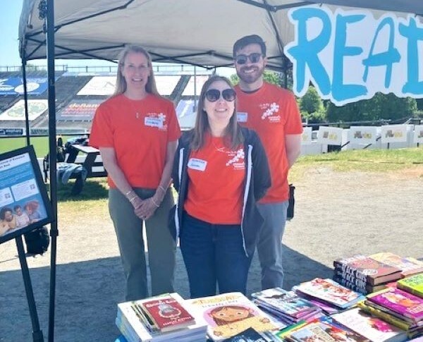 Volunteers standing a table full of books